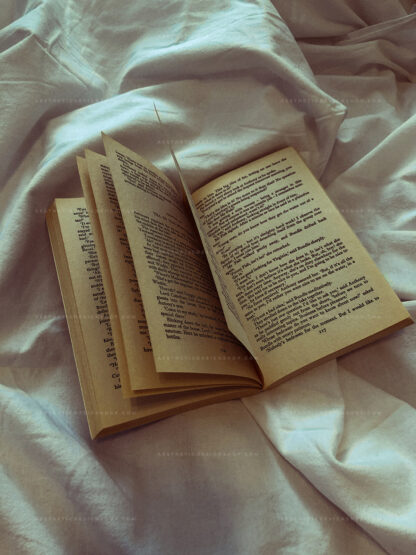 Aesthetic image of open book on white bed