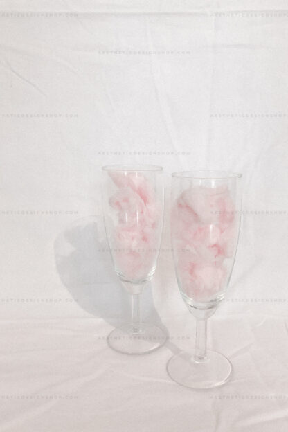 Aesthetic image of two champagne glasses filled with pink cotton candy